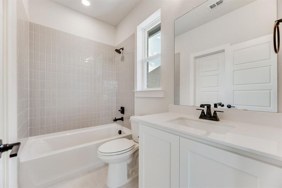 Full bath featuring shower / washtub combination, vanity, and light tile patterned floors Full bath featuring shower / washtub combination, vanity, and light tile patterned floors