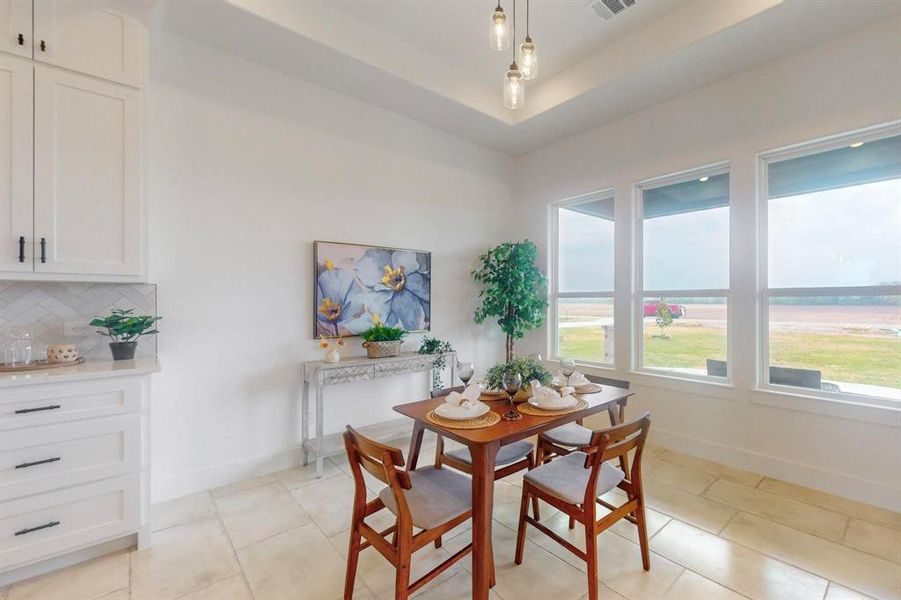 Dining space featuring a raised ceiling and light tile patterned flooring Dining space featuring a raised ceiling and light tile patterned flooring