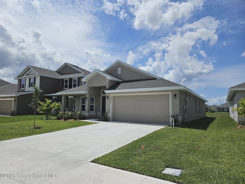 Front exterior of a new home in St. John Preserve, Palm Bay, FL, highlighting curb appeal (Image 2). Front exterior of a new home in St. John Preserve, Palm Bay, FL, highlighting curb appeal (Image 2).