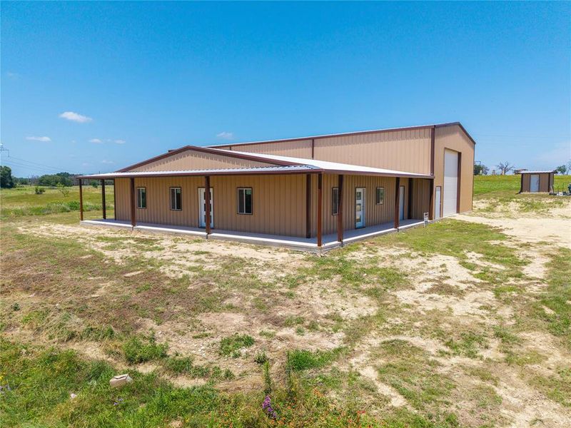 Rear view of property with a detached garage and an outdoor structure
