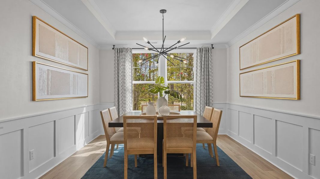 Elegant dining room with elevated tray ceiling and large window in the Jordan Design by DRB Homes in York, SC