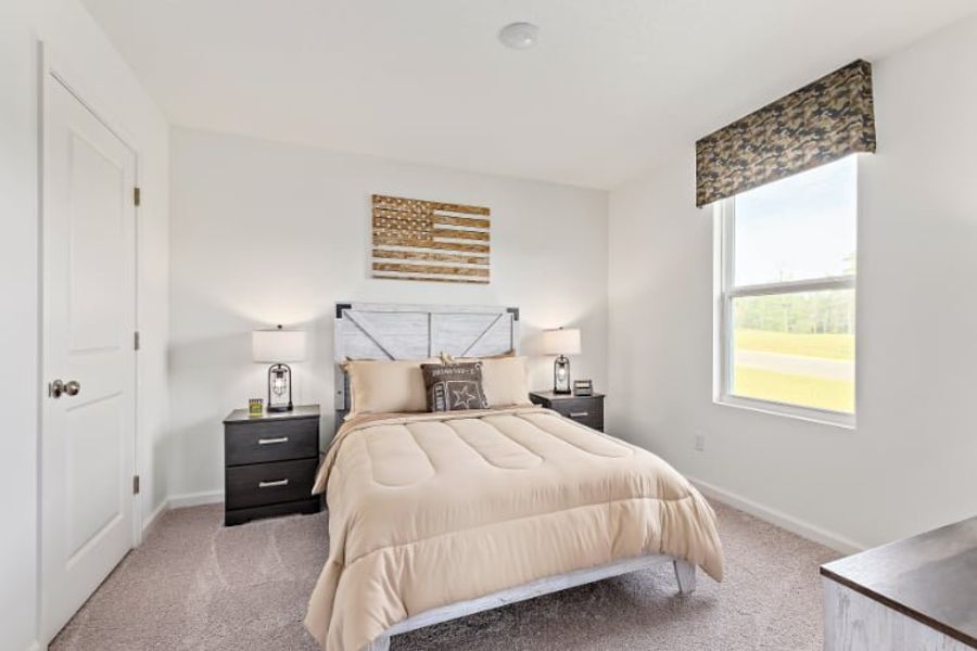 A bedroom with a bed and a window.