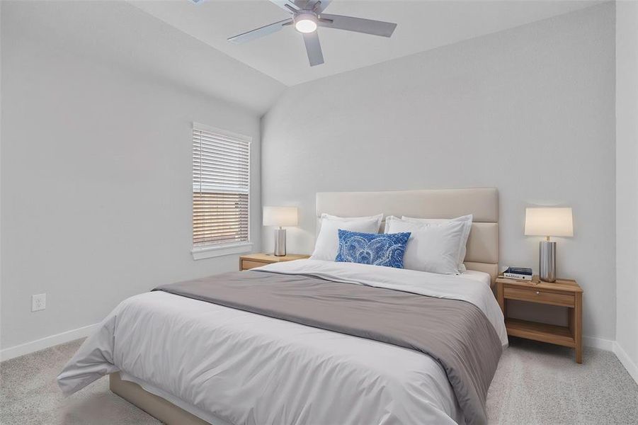 Secondary bedroom features plush carpet, neutral paint, ceiling fan, and a large window with privacy blinds.