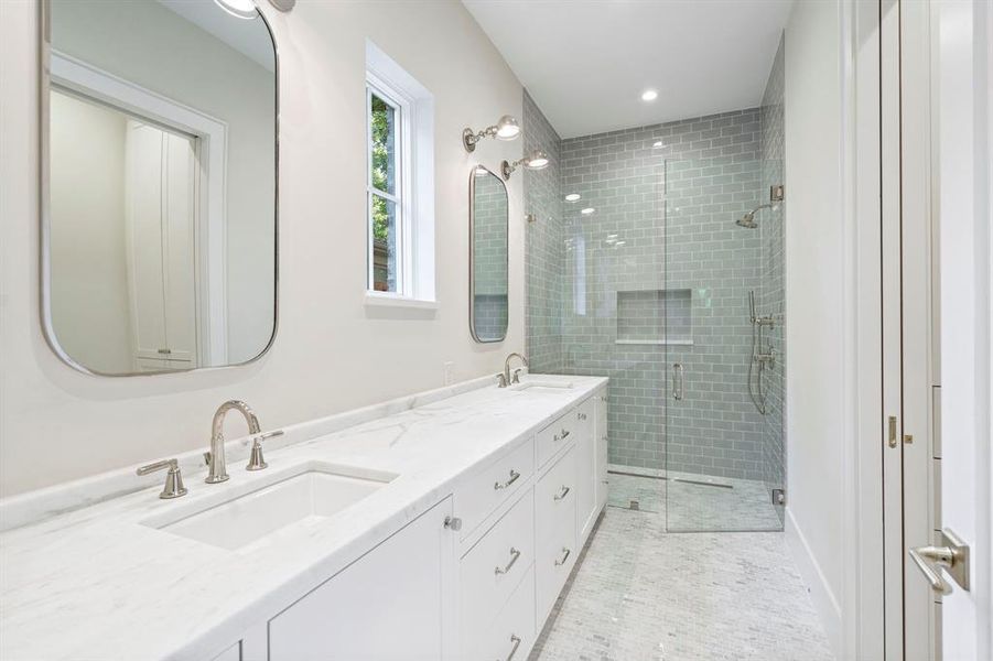 Bathroom with tile patterned floors, an enclosed shower, and double vanity