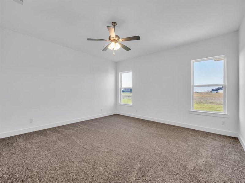 Unfurnished room featuring ceiling fan and carpet