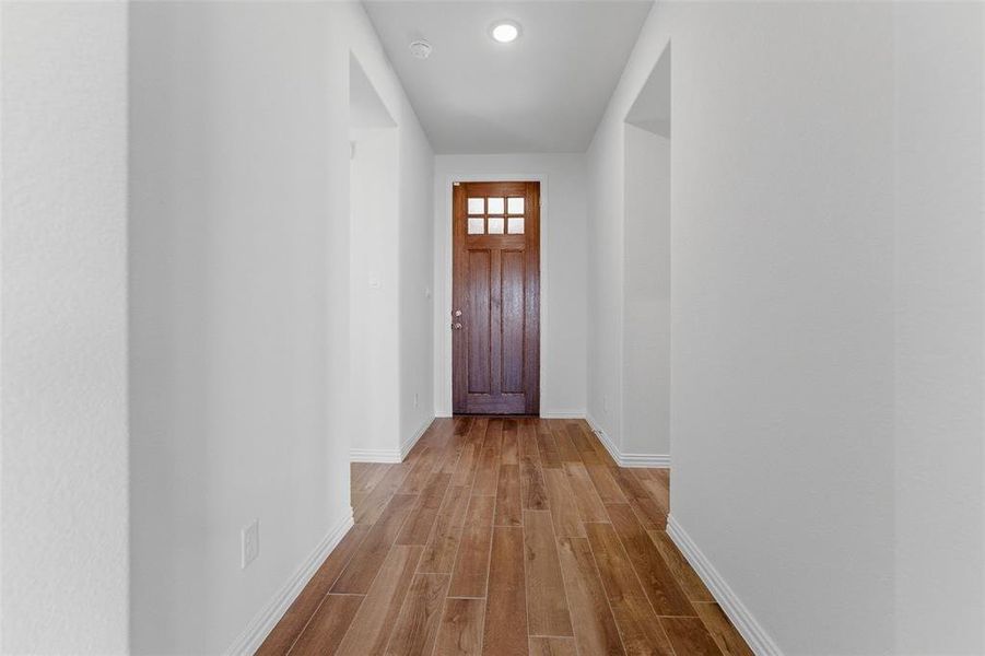 Doorway featuring wood finished floors and baseboards