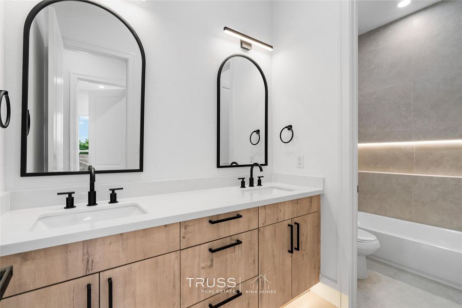 A full bath that carries the home’s modern DNA with sophisticated cabinetry, quartz counters, and streamlined fixtures.