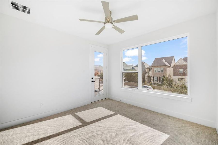 Spare room with a ceiling fan, visible vents, light carpet, and baseboards