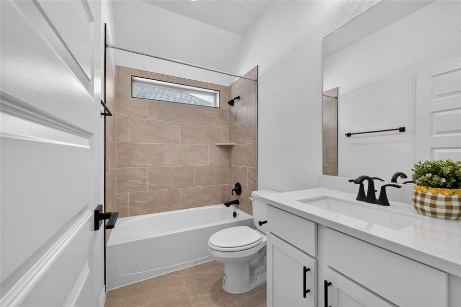 A vaulted ceiling and neutral wall tiles enhance this modern full bathroom. A vaulted ceiling and neutral wall tiles enhance this modern full bathroom.