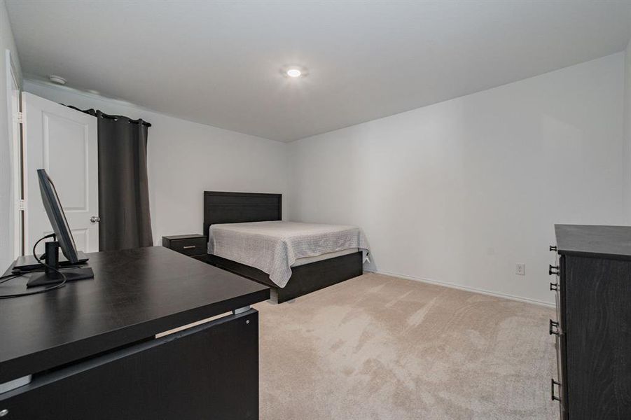 Bedroom with light colored carpet and baseboards
