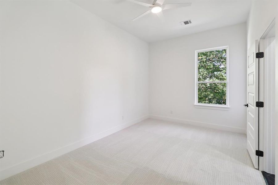Unfurnished room featuring light colored carpet and ceiling fan