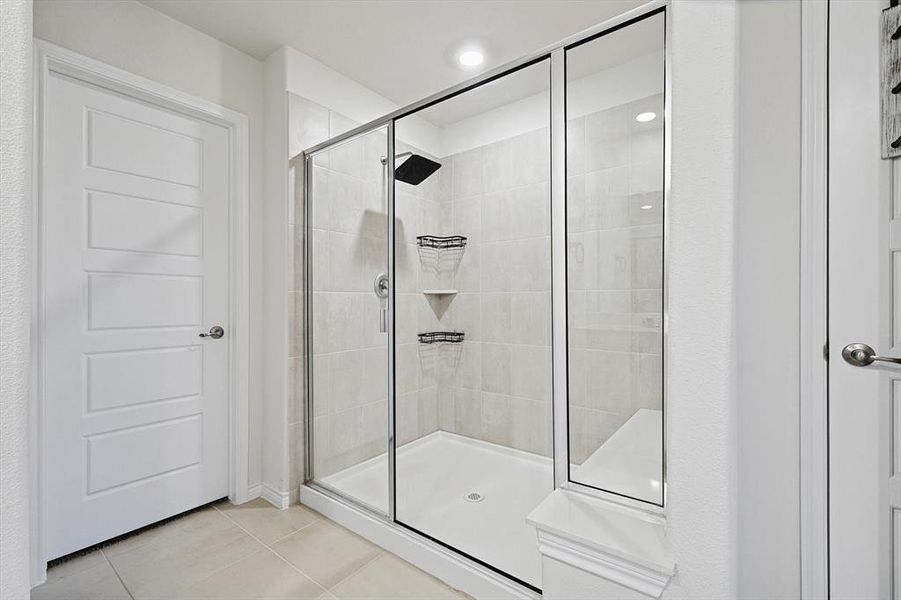 Bathroom with walk in shower and tile patterned flooring