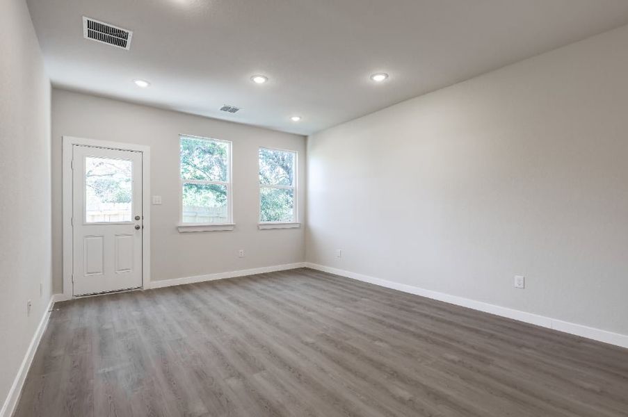 A room with a wood floor and a white door. A room with a wood floor and a white door.