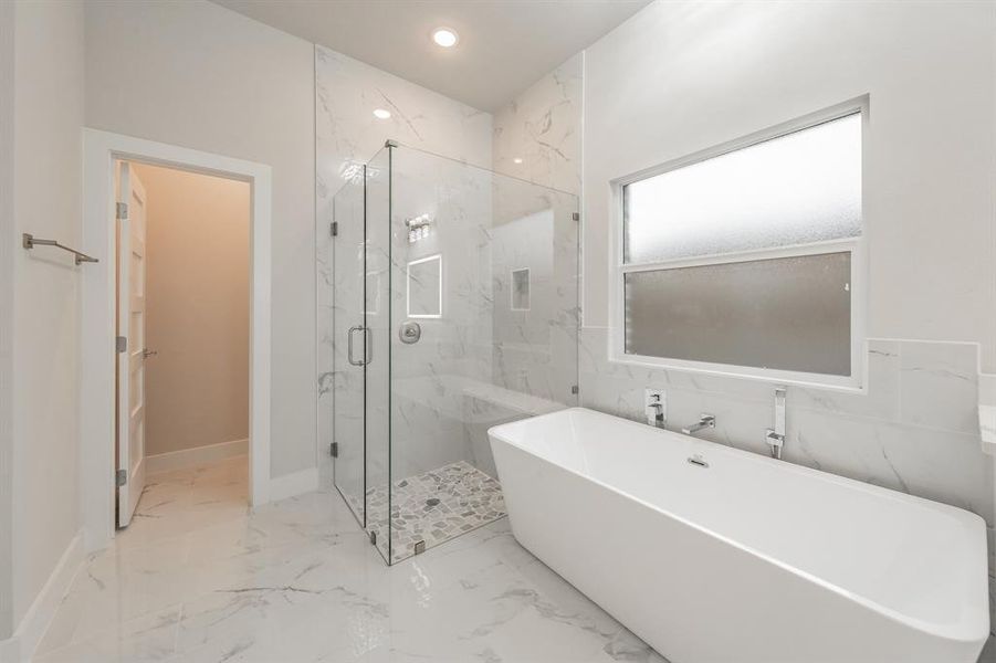 Full bath with a freestanding bath, light marble finish floors, a marble finish shower, and recessed lighting