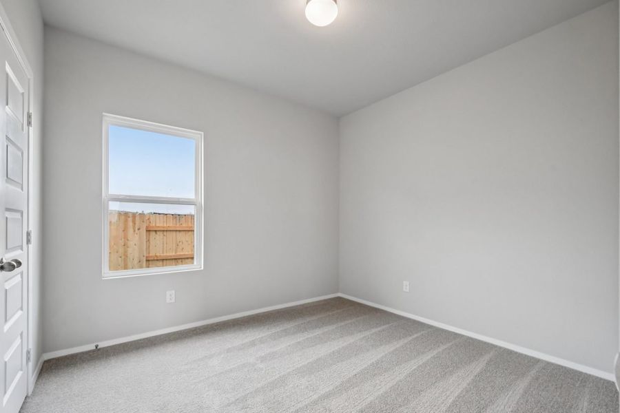 Image of a bedroom with grey walls, tan carpeting and a window