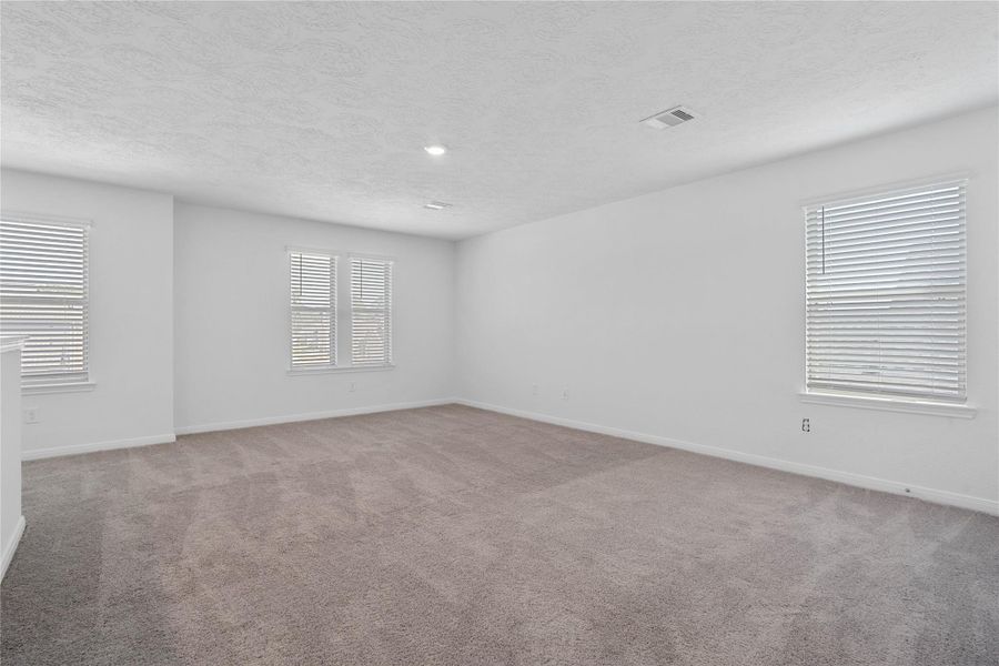 Head upstairs and enjoy the Loft—an additional living area perfect for a game room, media space, or a peaceful retreat. Featuring plush carpet flooring, neutral paint, high ceilings, recessed lighting, and windows with blinds.