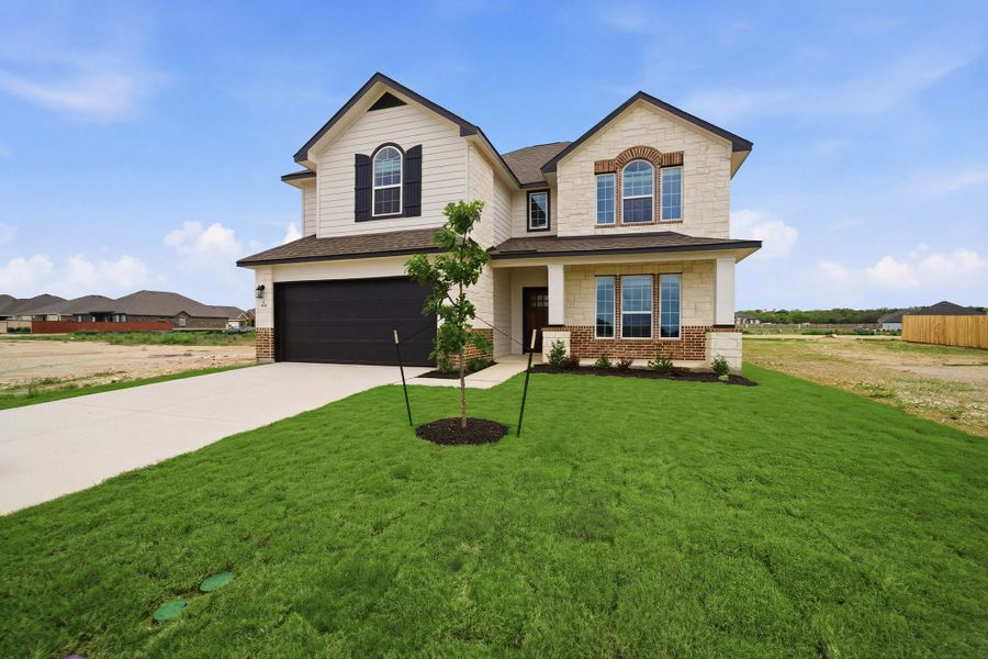Front exterior of a new home in Megan's Landing, Castroville, TX, highlighting curb appeal (Image 2).