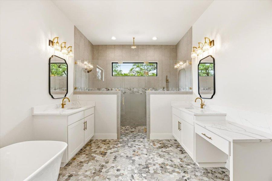 A lavish primary bathroom features a freestanding tub and a spacious dual-head shower with a built-in bench.