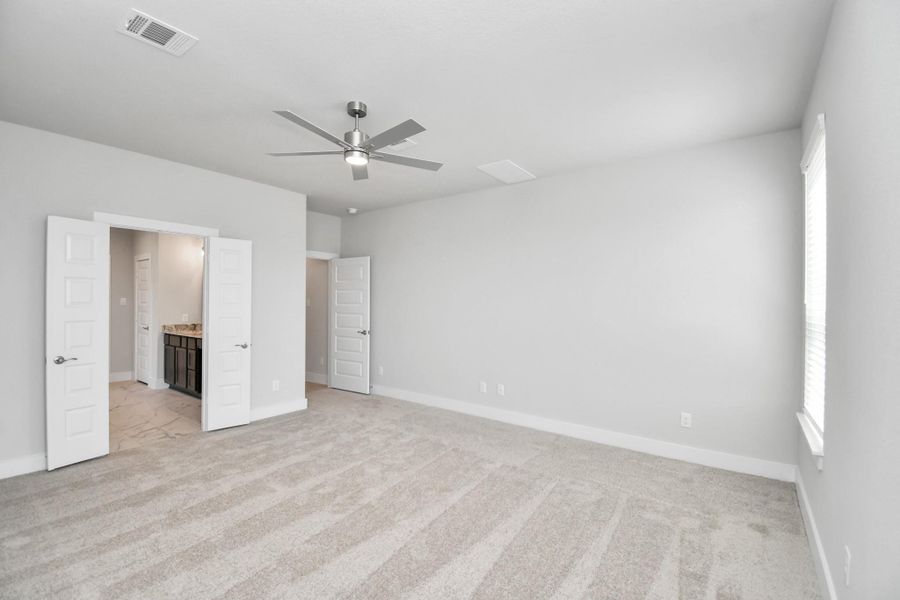 Escape the day's chaos and find serenity in the grand primary suite! Enjoy the comfort of plush carpeting, soothing paint hues, high ceilings, and large windows fitted with privacy blinds. Sample photo of completed home with similar floor plan. Actual colors and selections may vary.