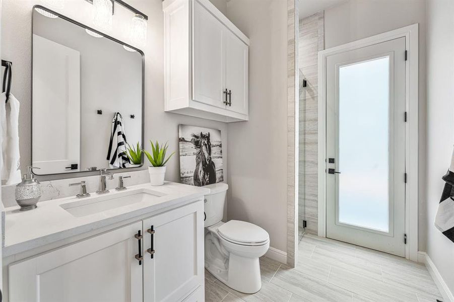 Bathroom with walk in shower, tile patterned flooring, toilet, and vanity