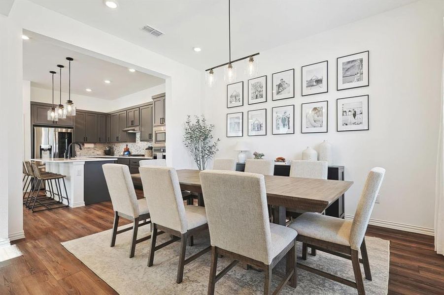 Dining space featuring a notable chandelier, sink, and dark hardwood / wood-style flooring