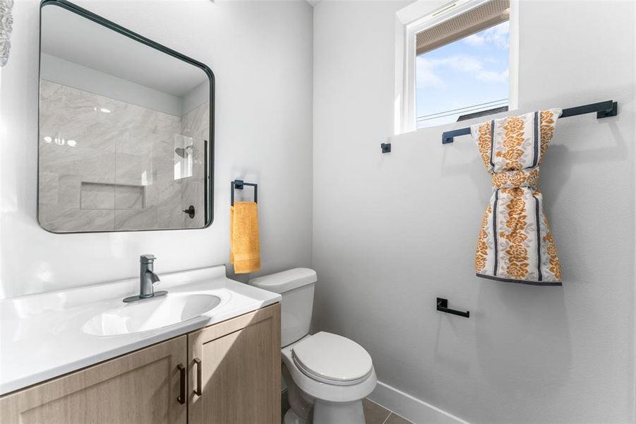 Bathroom with a marble finish shower and vanity