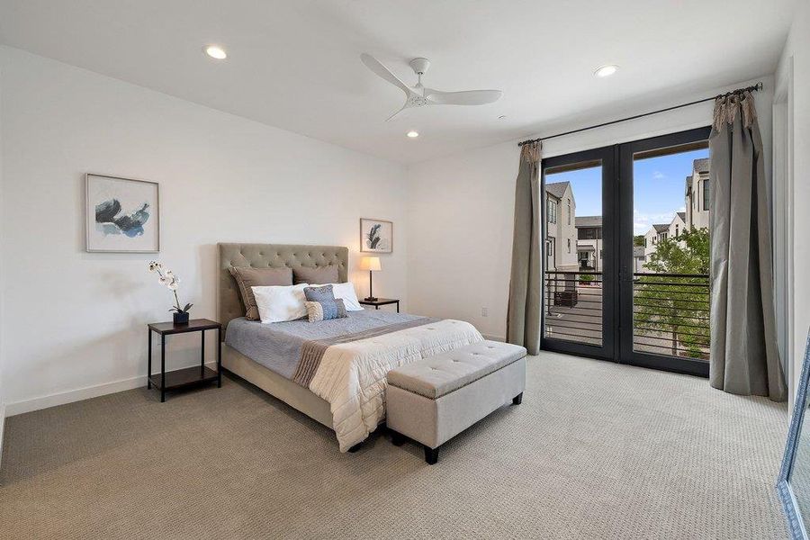 Spacious bedroom featuring light-toned carpeting, recessed ceiling lighting, and a modern ceiling fan