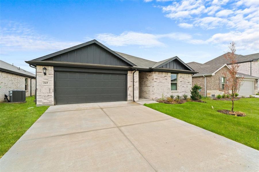 Single story home featuring an attached garage, concrete driveway, a front lawn, board and batten siding, and brick siding Single story home featuring an attached garage, concrete driveway, a front lawn, board and batten siding, and brick siding