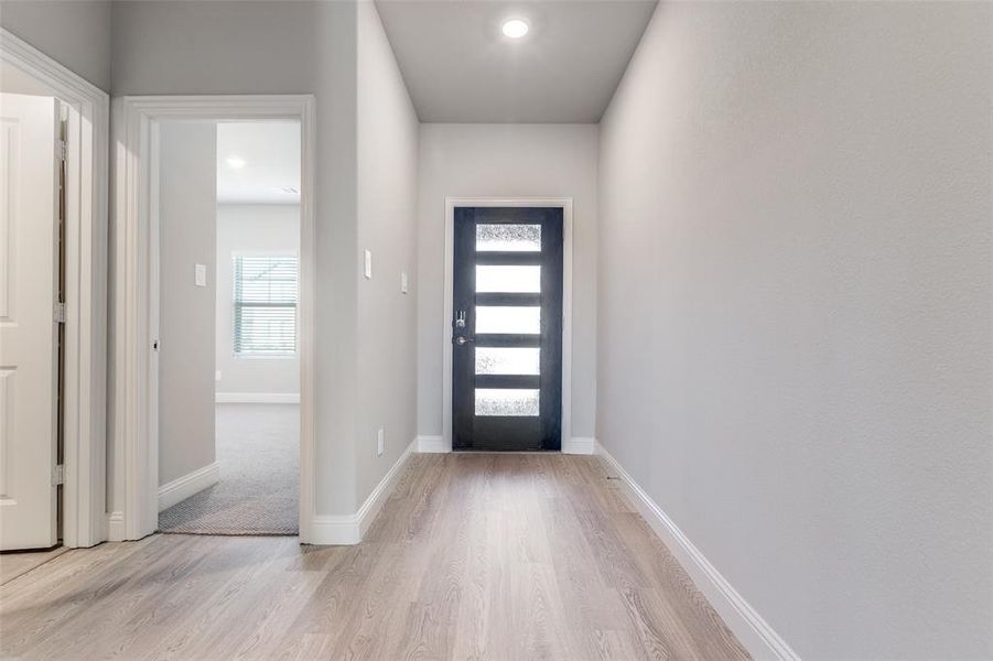Entryway with light wood-type flooring and recessed lighting