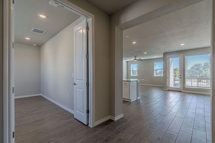 Hallway with dark wood-type flooring and recessed lighting Hallway with dark wood-type flooring and recessed lighting