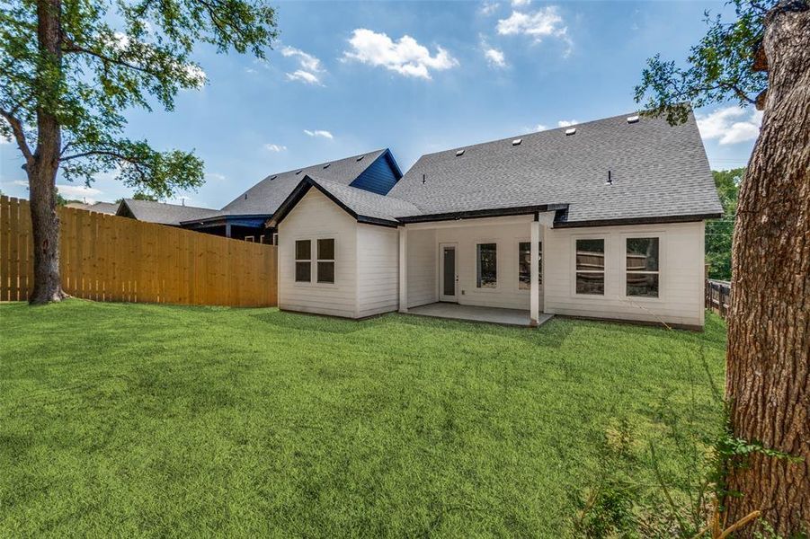 Expansive backyard featuring a manicured lawn, a full wooden privacy fence, and mature trees Expansive backyard featuring a manicured lawn, a full wooden privacy fence, and mature trees