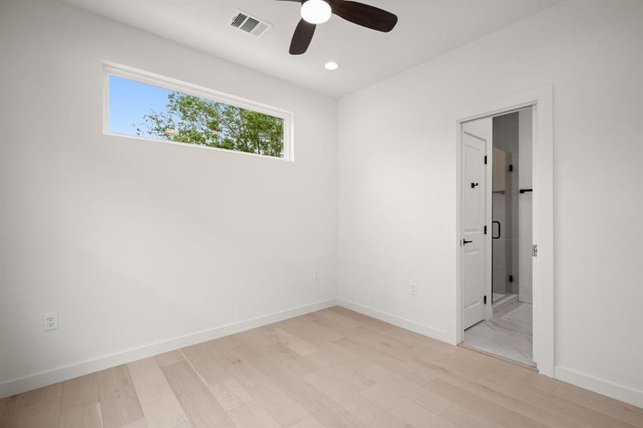 Unfurnished bedroom featuring light wood finished floors, ceiling fan, recessed lighting, and connected bathroom