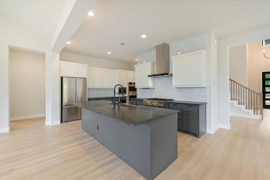 Culinary dream kitchen boasts ample counter space, a large island, and contemporary stainless steel appliances.