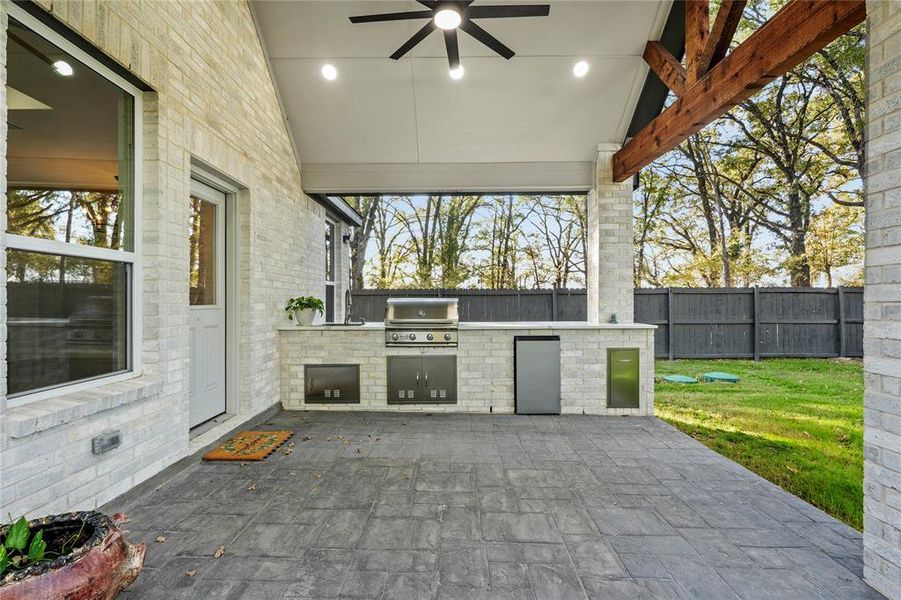 Fenced backyard with area for grilling, a ceiling fan, and a patio area