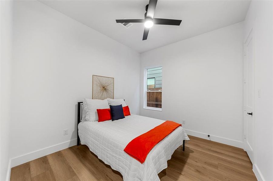 Bedroom featuring light wood finished floors and a ceiling fan Bedroom featuring light wood finished floors and a ceiling fan