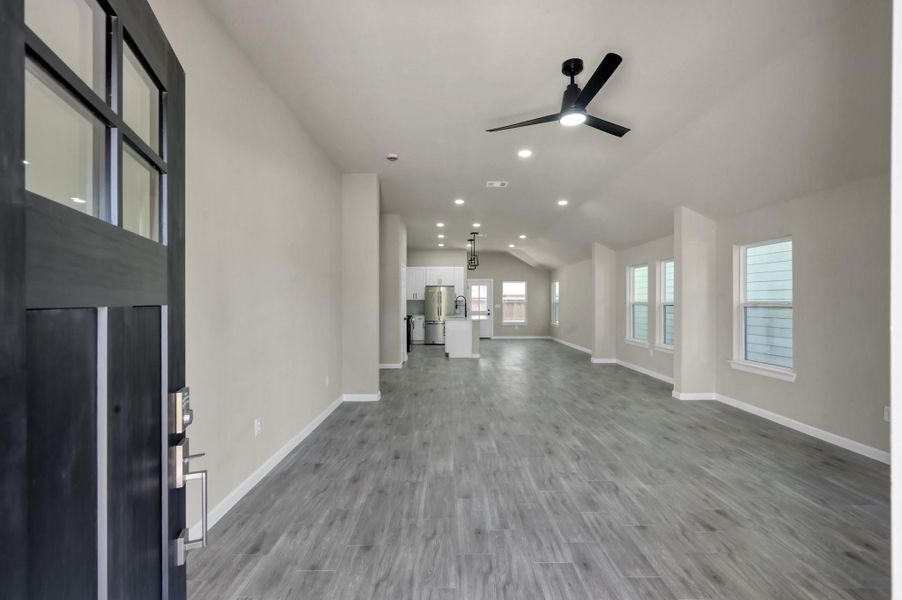 Step inside to an expansive open-concept layout featuring durable luxury tile flooring and soaring vaulted ceilings that create an airy, light-filled atmosphere.