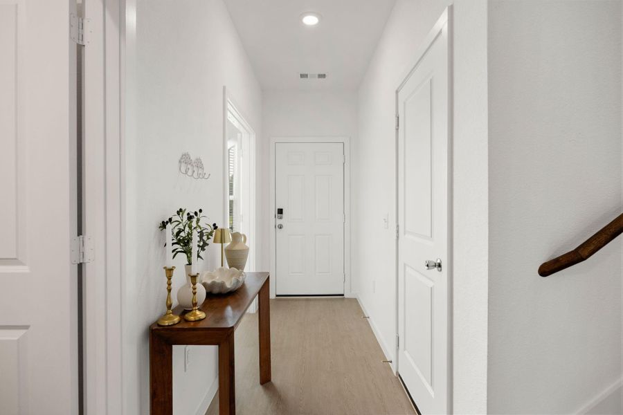 The spacious foyer creates an inviting first impression and provides convenient access to the downstairs secondary bedroom, half bath, and main living areas.