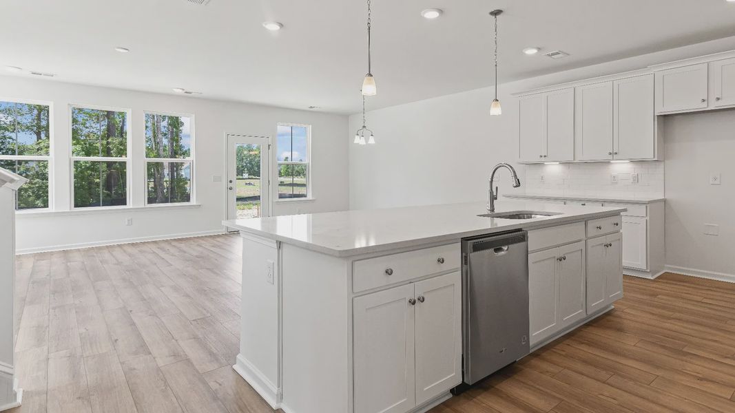 Open concept kitchen with generous island for hosting in the Heron townhome plan by DRB Homes