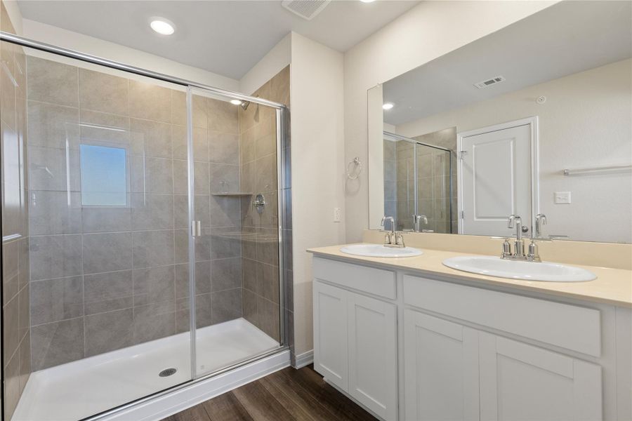 Master Bathroom featuring double vanity, dark wood-type flooring, a shower stall, and recessed lighting Master Bathroom featuring double vanity, dark wood-type flooring, a shower stall, and recessed lighting