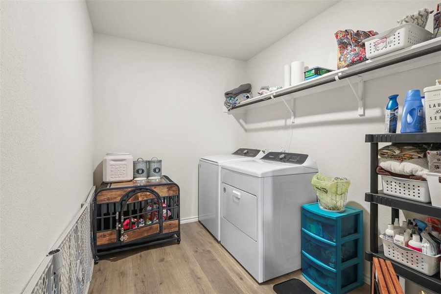 Laundry area featuring light wood-style floors and washing machine and clothes dryer