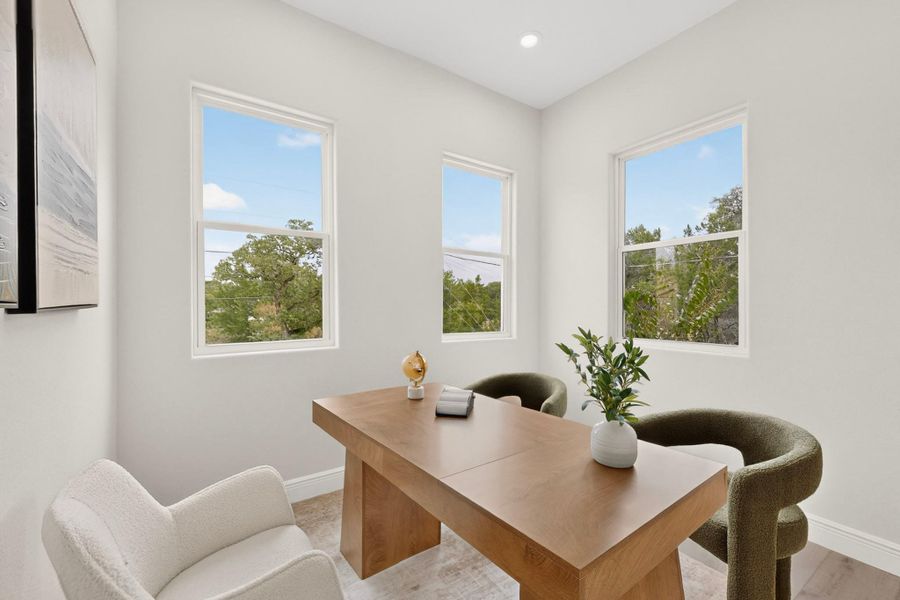 Crisp white walls frame views of surrounding treetops through numerous tall windows.