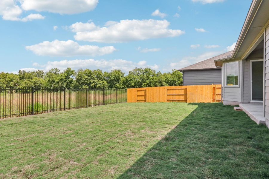 Fenced backyard with view of scattered trees Fenced backyard with view of scattered trees
