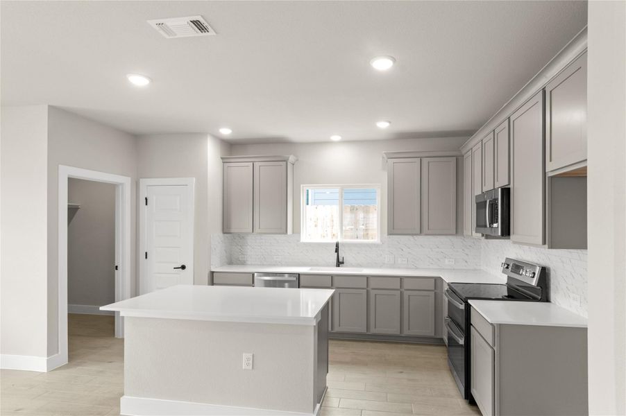 Kitchen featuring gray cabinetry, stainless steel appliances, a sink, and recessed lighting Kitchen featuring gray cabinetry, stainless steel appliances, a sink, and recessed lighting