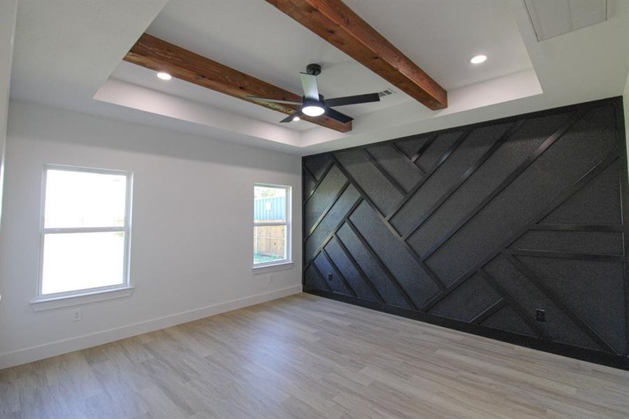 Spare room with light wood-style flooring, a ceiling fan, beam ceiling, recessed lighting, and a barn door Spare room with light wood-style flooring, a ceiling fan, beam ceiling, recessed lighting, and a barn door