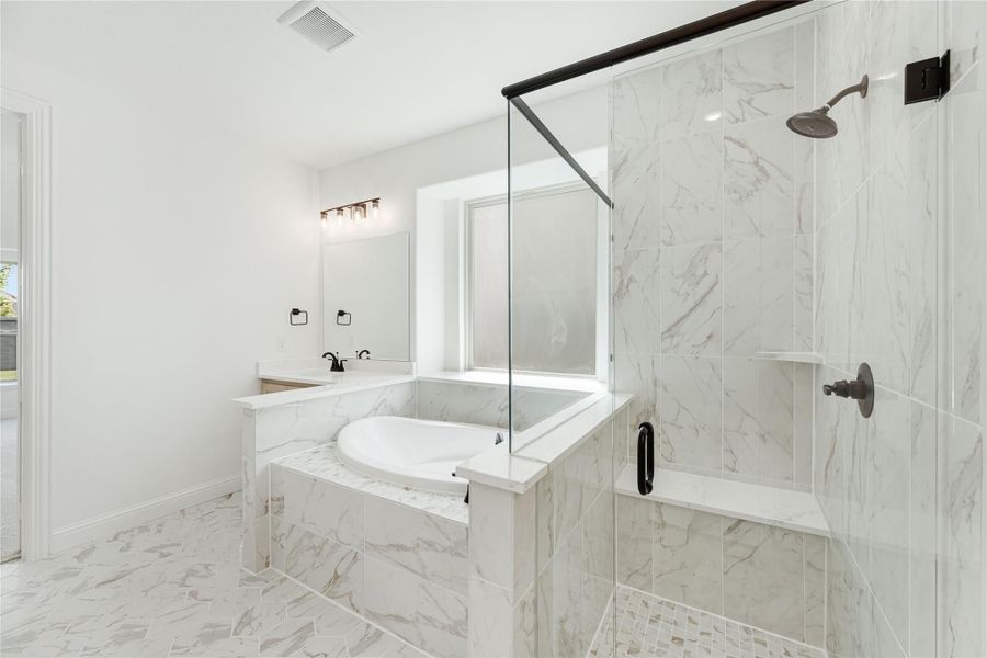 Bathroom with marble tile, soaking tub, glass-enclosed walk-in shower, and black fixtures Bathroom with marble tile, soaking tub, glass-enclosed walk-in shower, and black fixtures