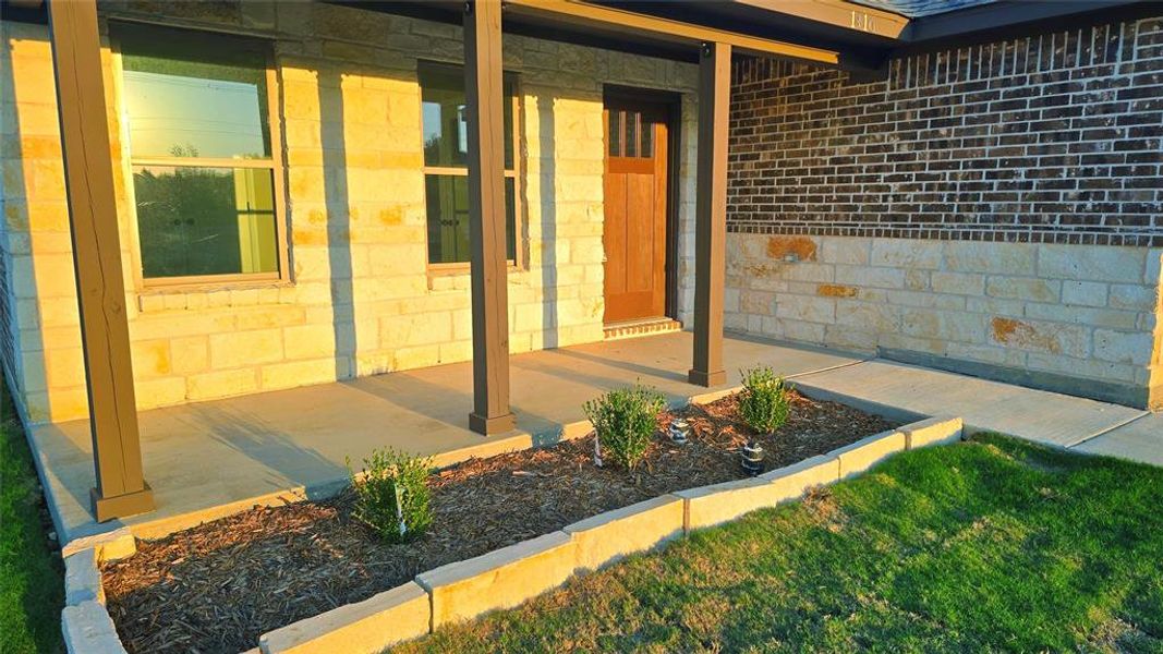 Property entrance with covered porch and stone siding