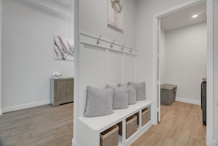 Directly off the three-car garage, the home opens into a well-appointed mudroom—an ideal drop zone for outerwear and everyday items—enhanced by an adjacent linen closet that adds valuable storage and convenience.