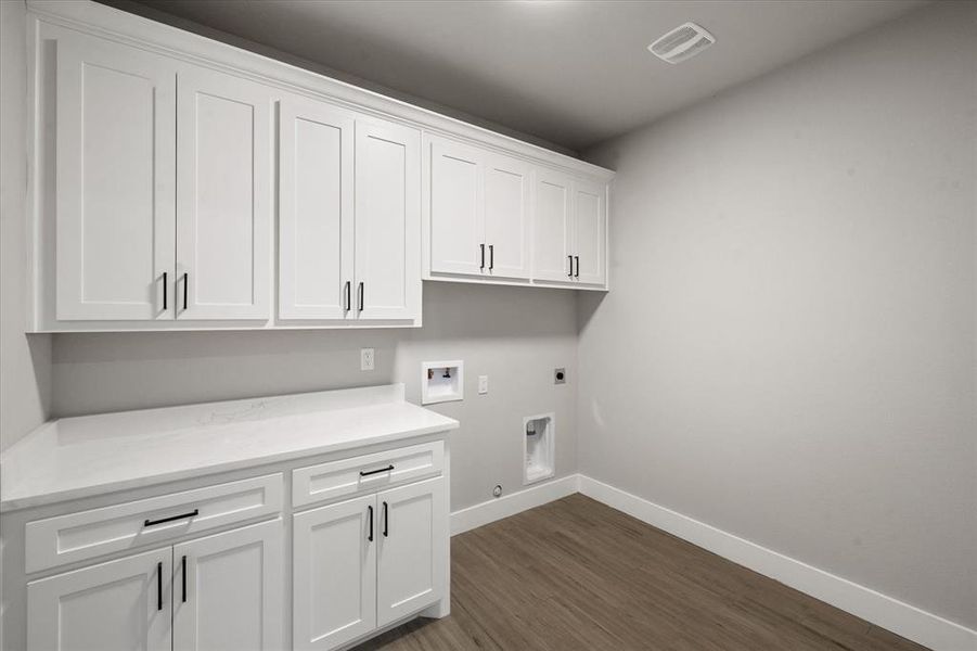 Washroom featuring washer hookup, hookup for an electric dryer, gas dryer hookup, cabinets, and dark hardwood / wood-style flooring