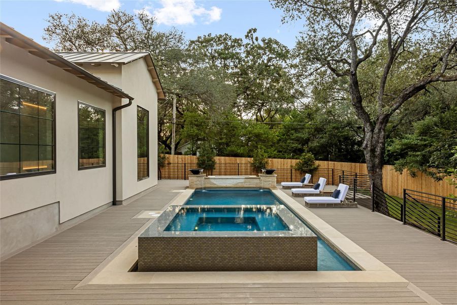 Stately columns support a covered terrace overlooking the tiered backyard decking.