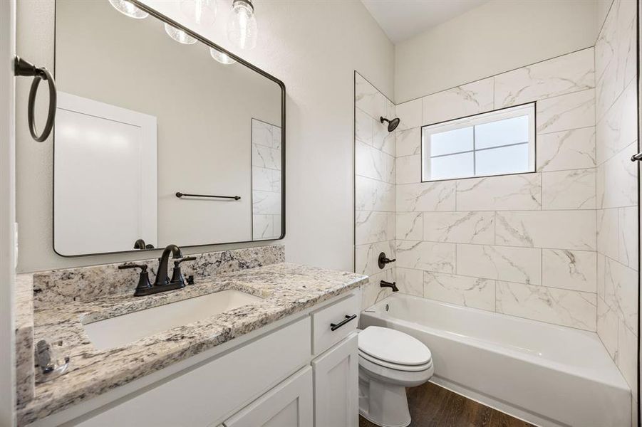 Bathroom with shower combination, vanity, and dark wood-type flooring Bathroom with shower combination, vanity, and dark wood-type flooring
